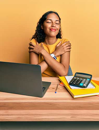 woman hugging self at desk