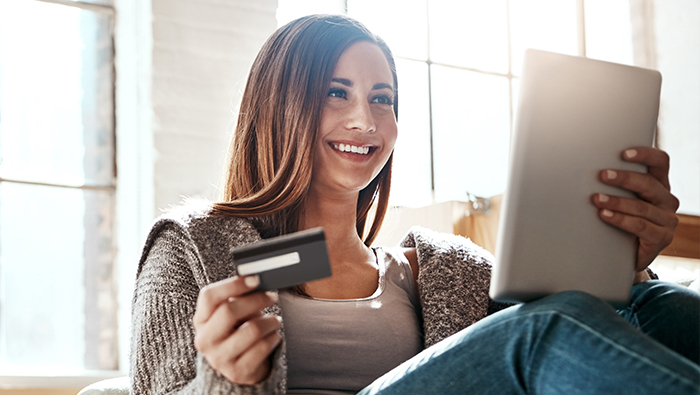 Woman holding card and tablet