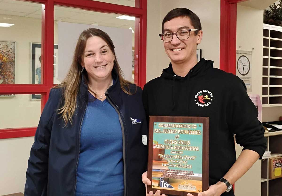 TCT FCU Community Relations Manager, Jeannie Dickinson, presents the Teacher of the Week plaque to Music Teacher, Jeremy Bouteiller of Glens Falls Middle/High School.